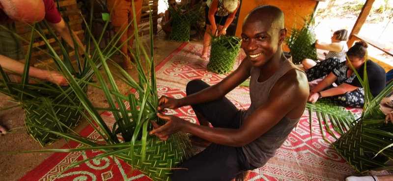Hassani Soulaimana, d'Aromaoré, souriant, tresse des feuilles à Mayotte